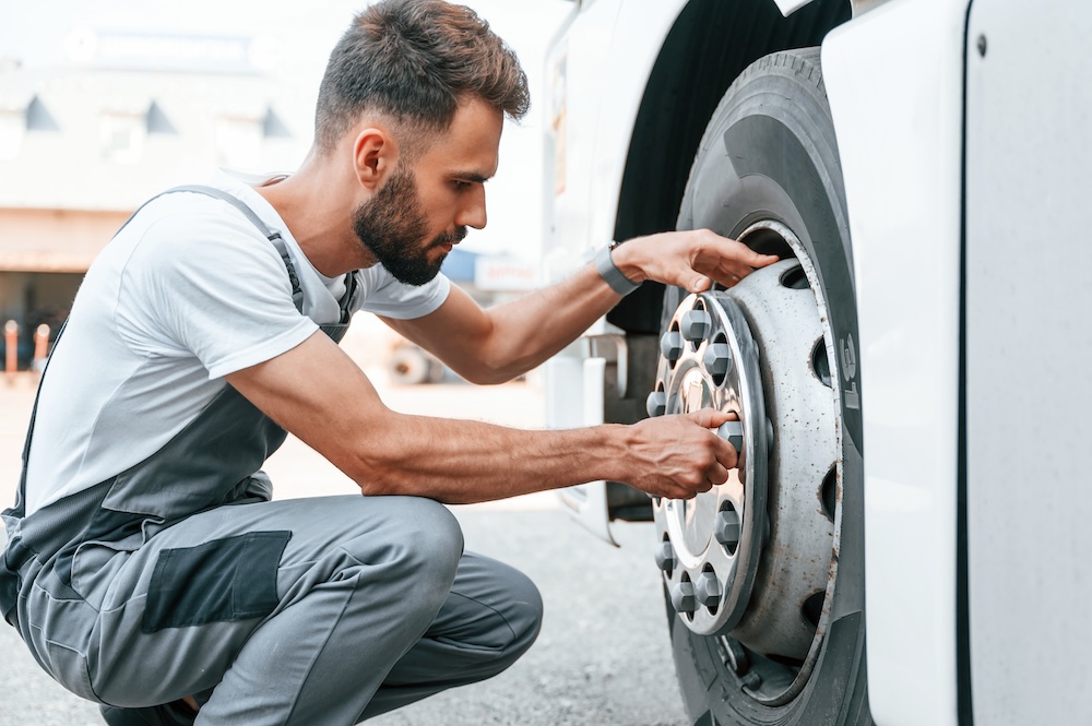 a man fix a big truck tire