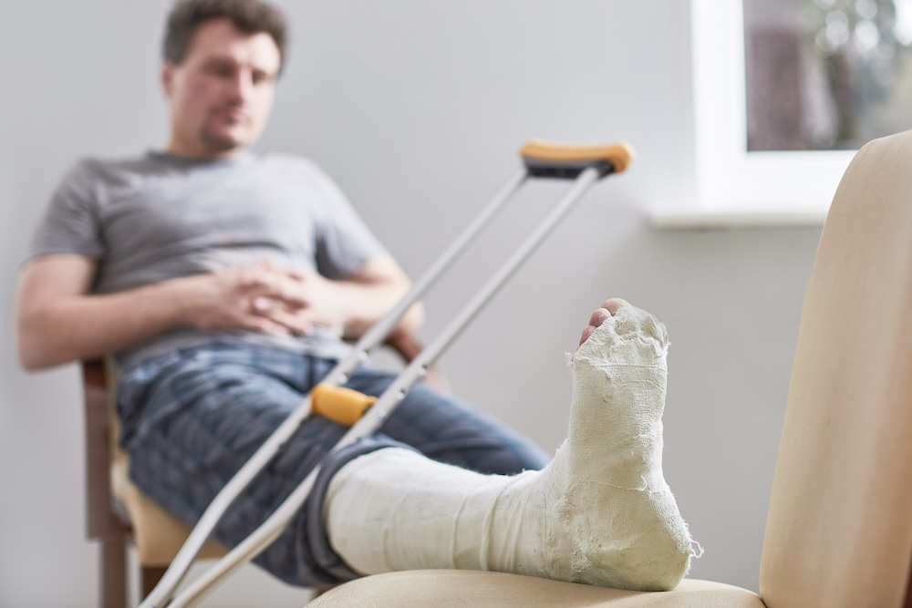 guy sitting in a chair with a broken leg in a cast