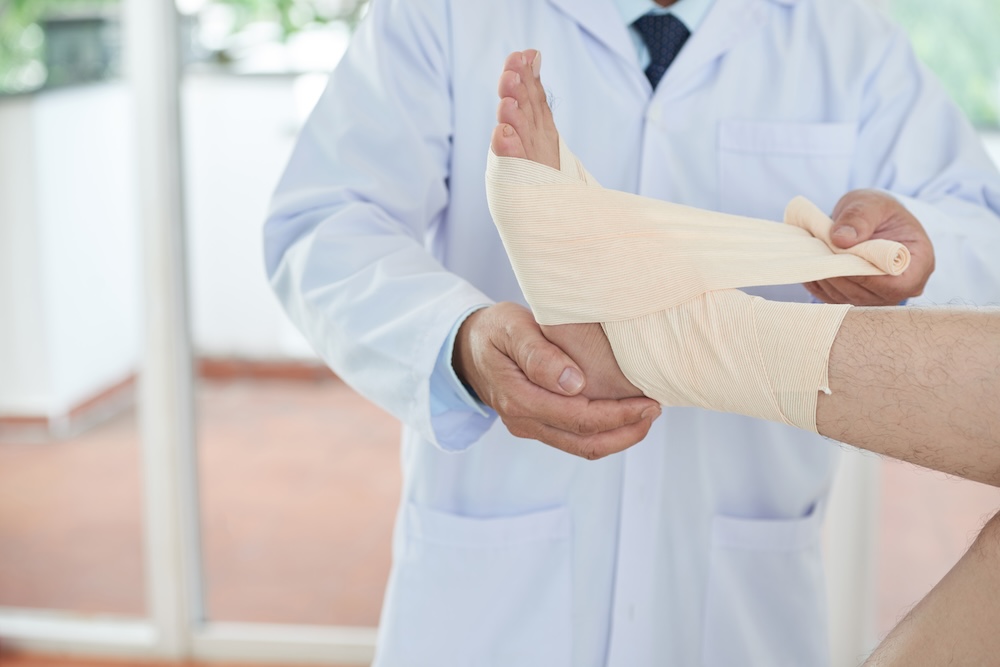 a person getting their ankle wrapped by a doctor